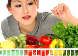 Woman Looking at Vegetables in Refrigerator ca. 2003