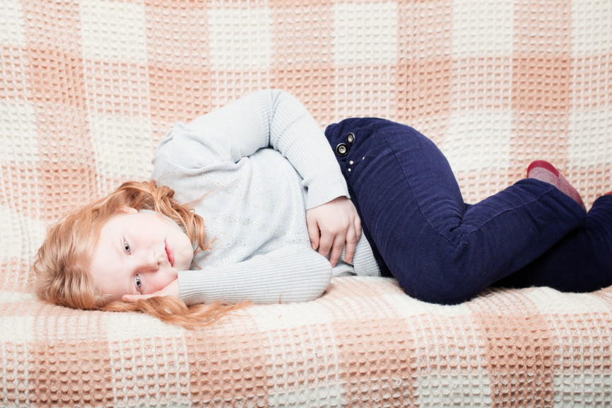child with stomach ache in sofa