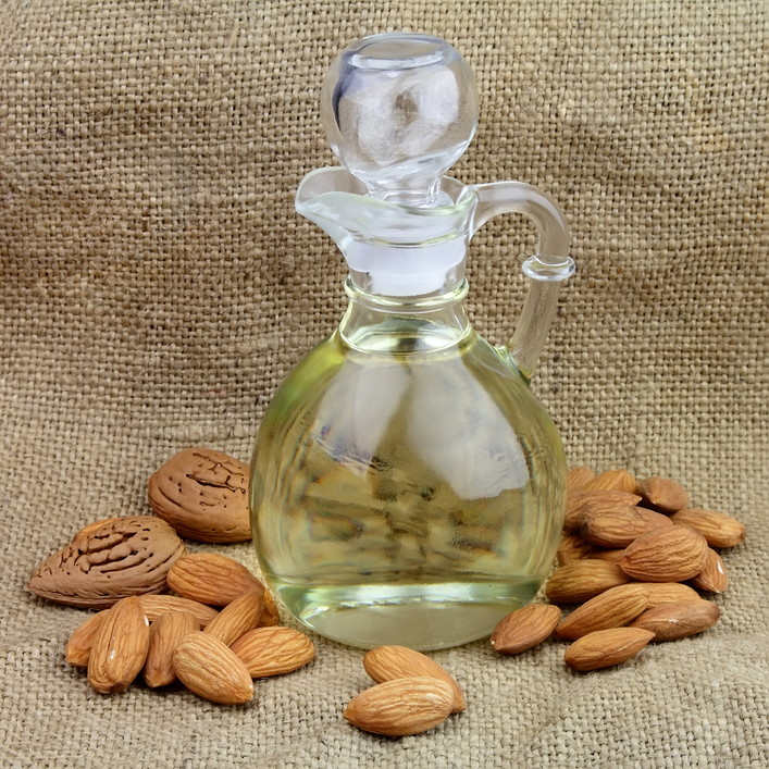 A bottle of almond oil with nuts