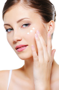 Female applying cosmetic cream on skin