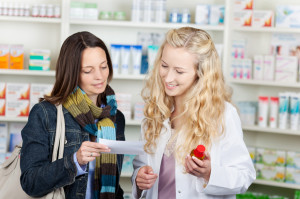 Pharmacist And Customer Reading Prescription Paper