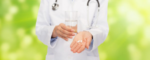 close up of doctor offering pills and water